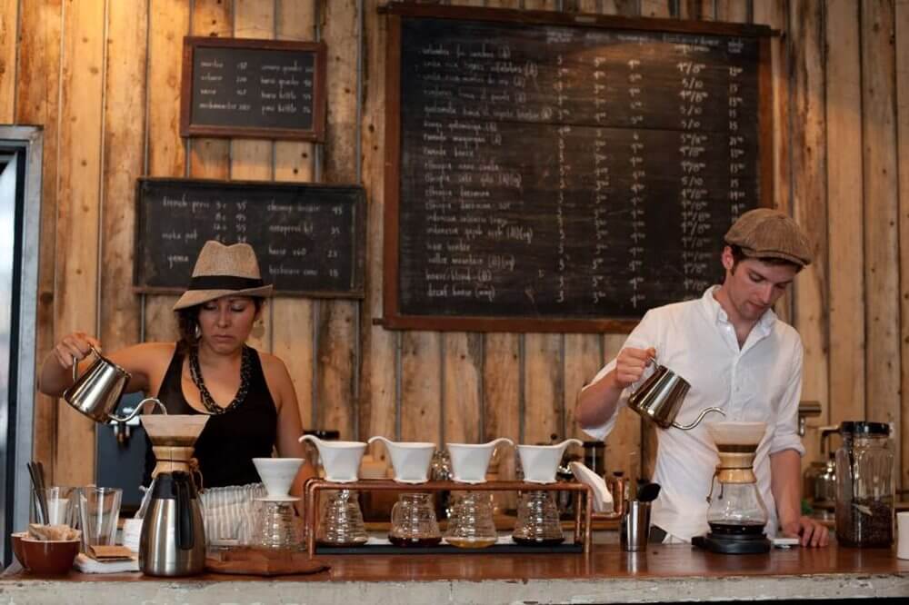 Two baristas preparing coffee.